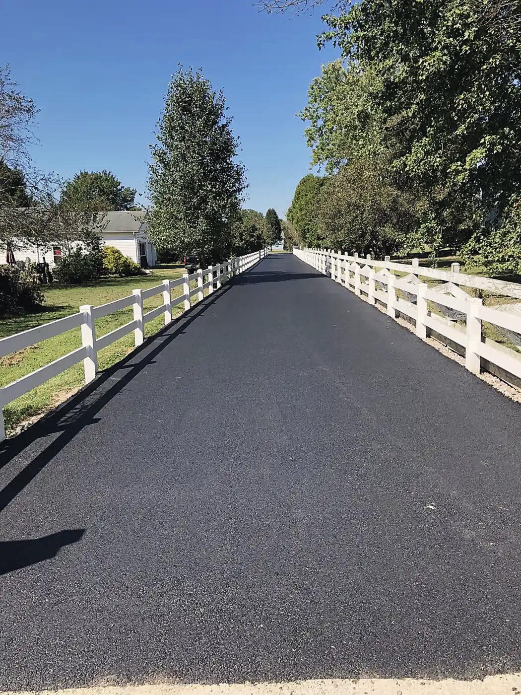 A new asphalt lane between white board fences