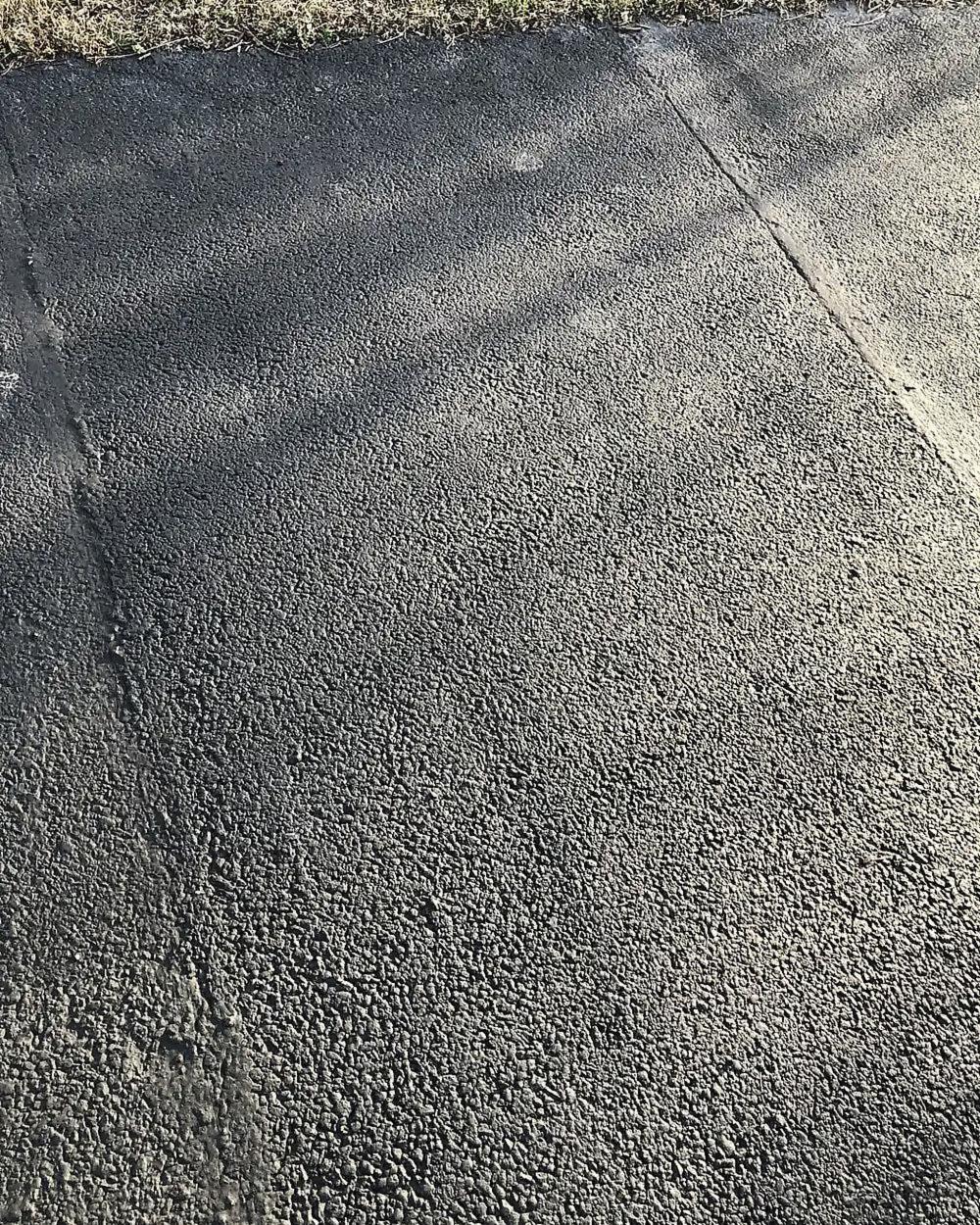 A new asphalt patch blended into an older drive